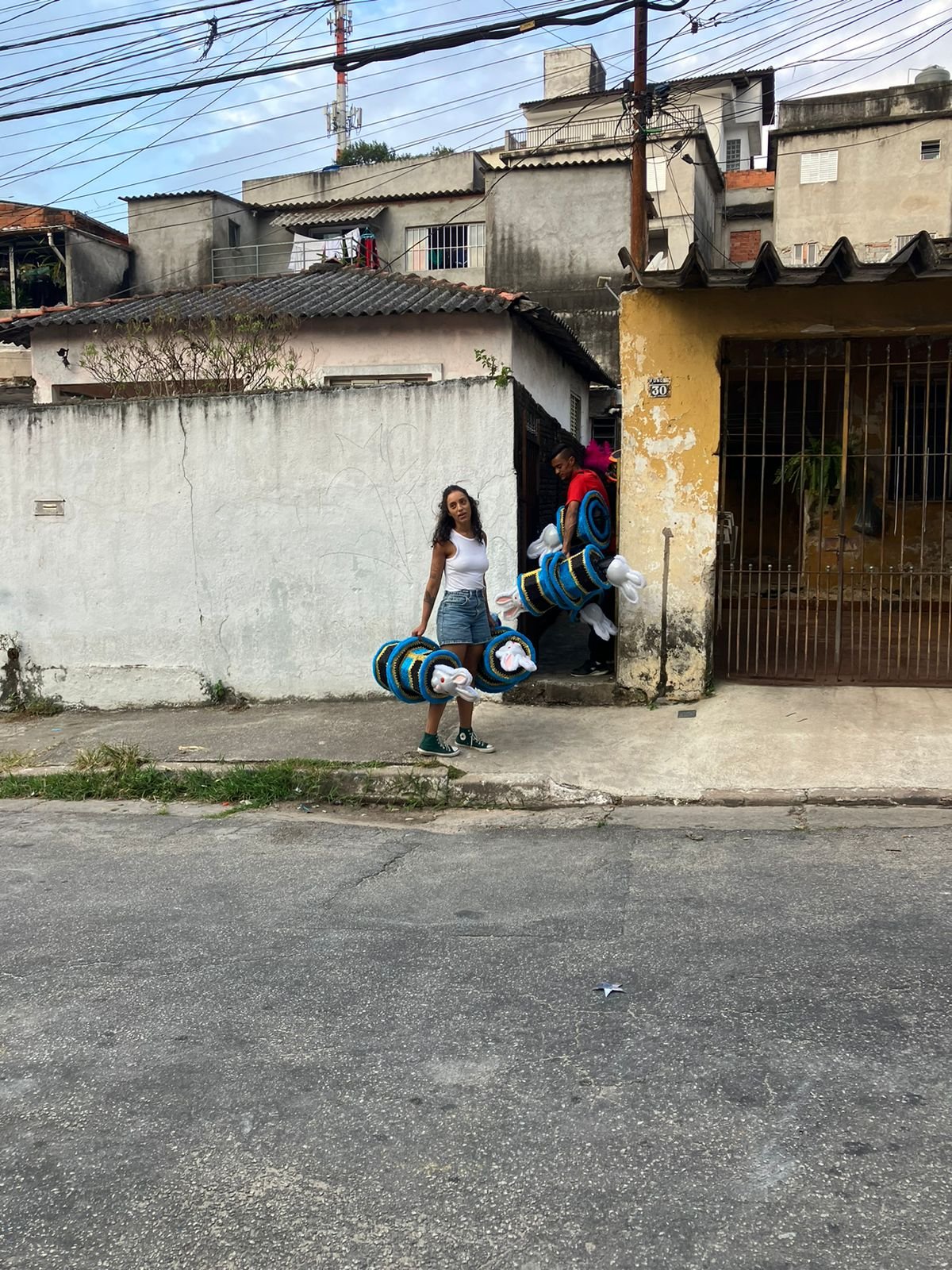 Imagem de integrantes do coletivo carregando fantasias de carnaval