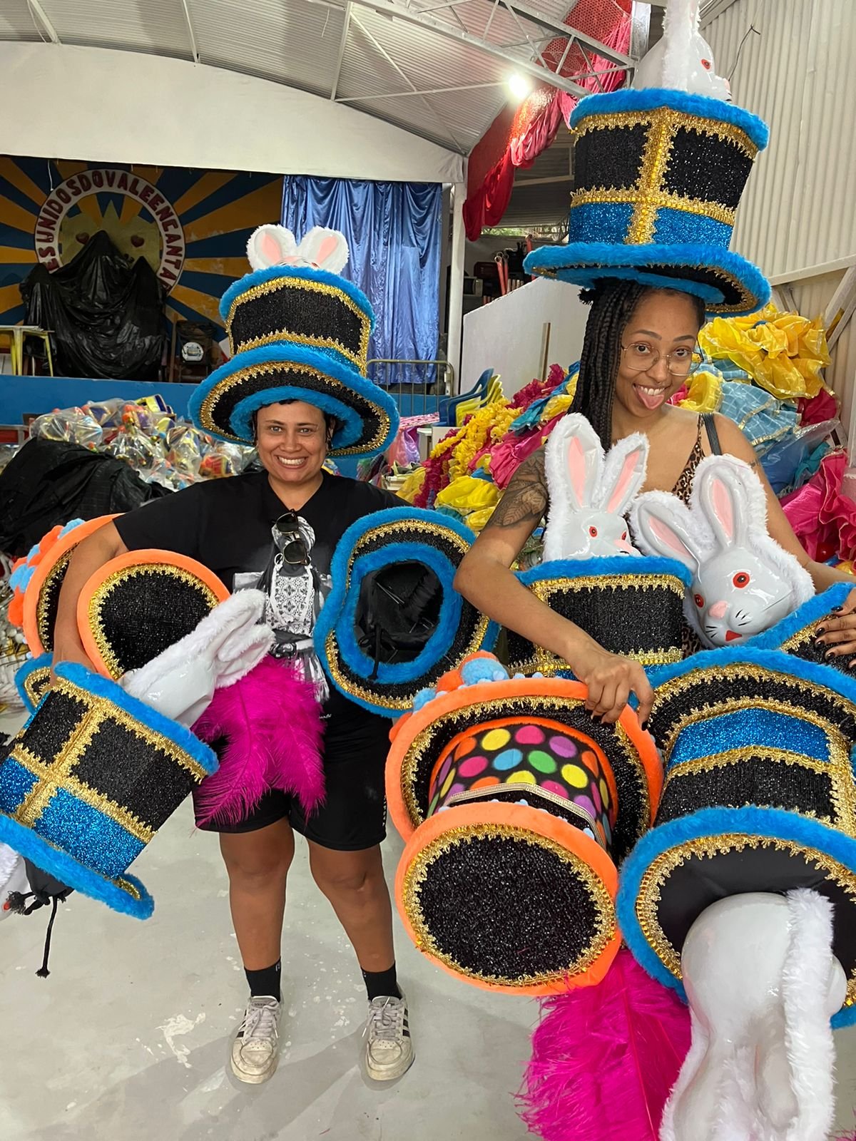 Imagem de 2 pessoas carregando fantasias de carnaval