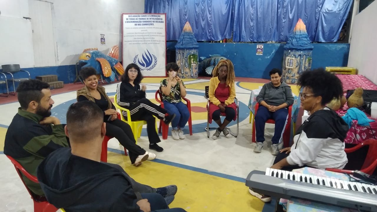 Imagem de pessoas sentadas em cadeiras na aula de canto
